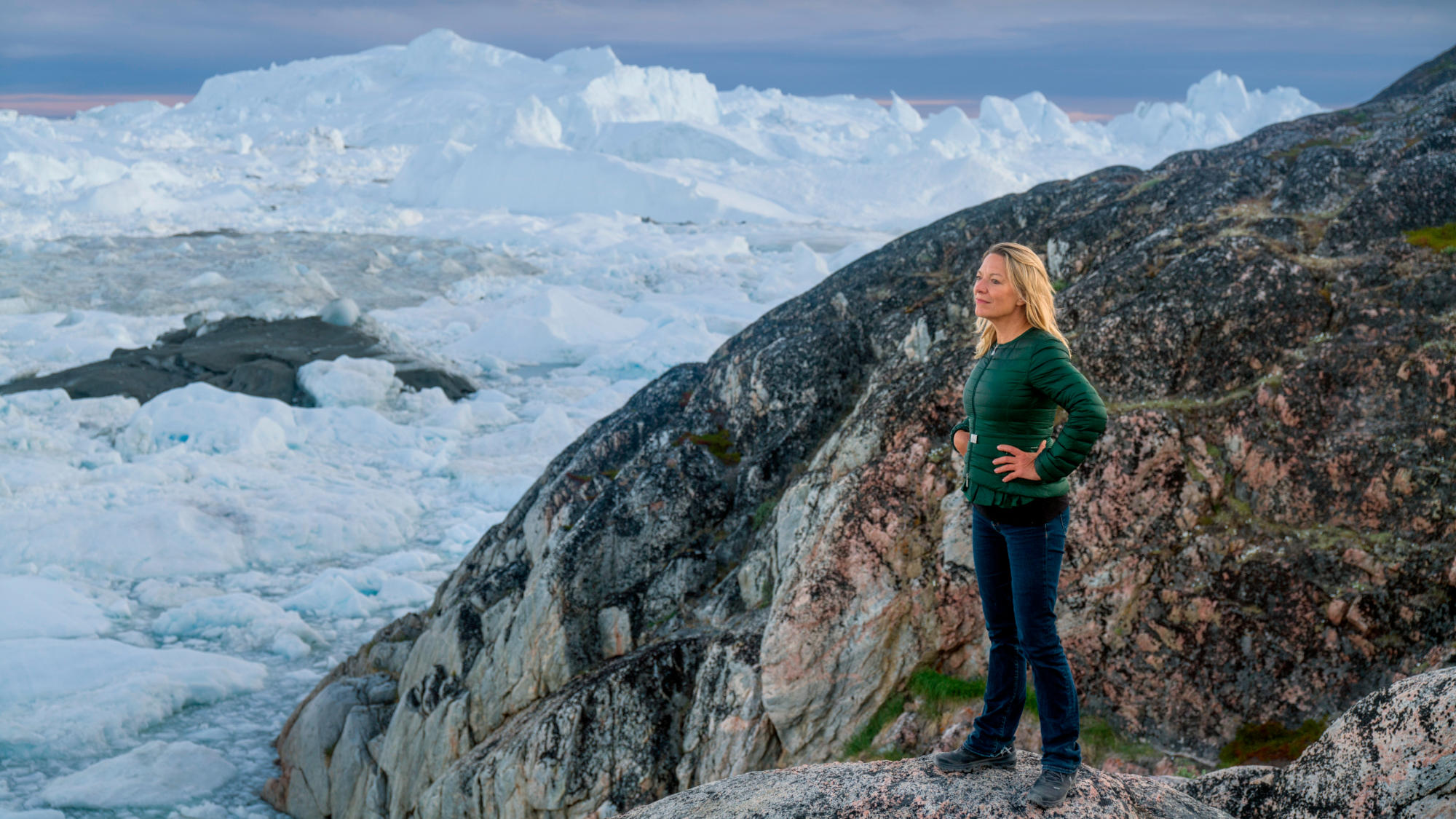 Antje Boetius steht auf einem Fels, sie schaut auf die umliegende Eislandschaft