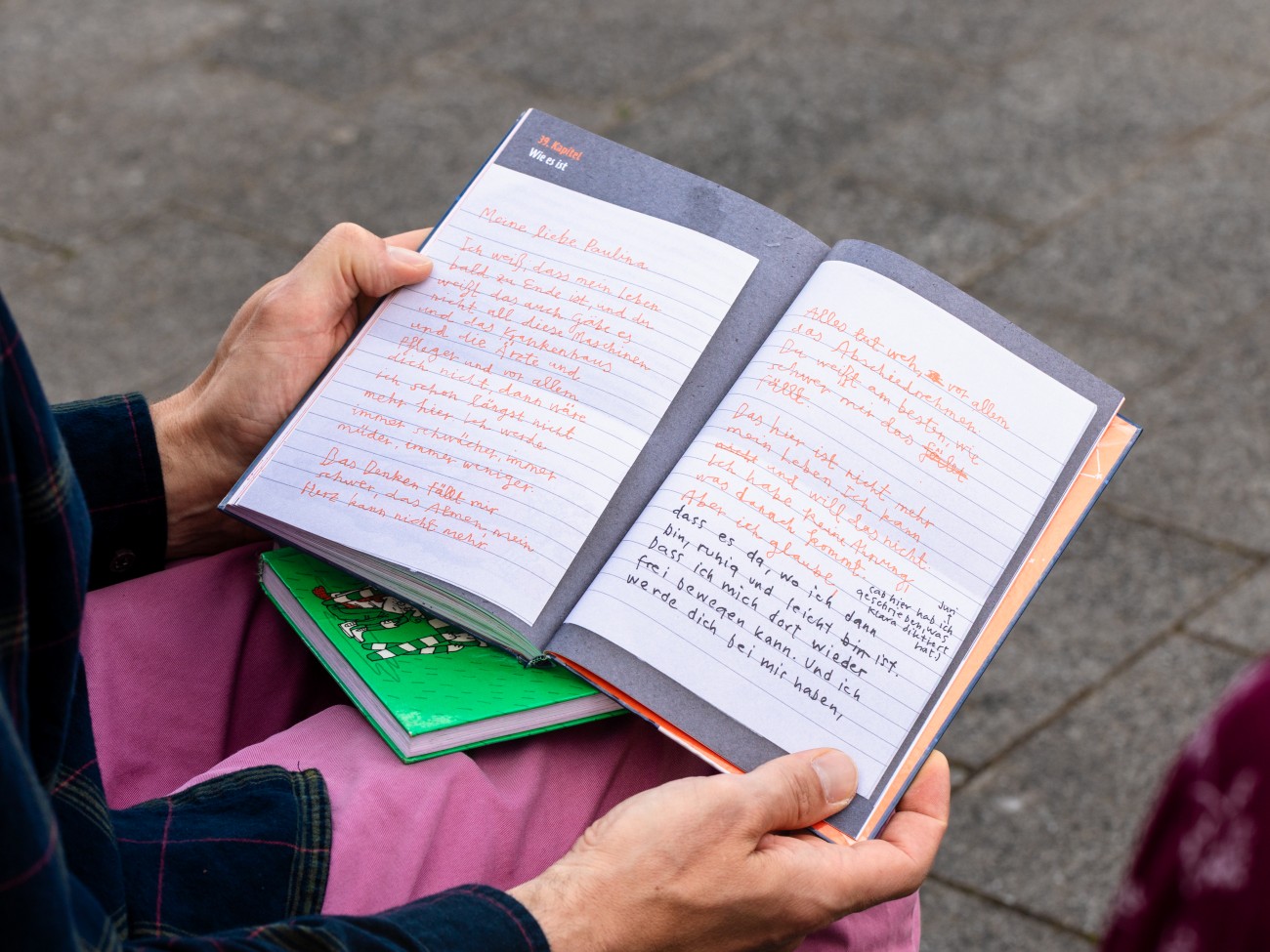Zwei Hände halten ein Buch aufgeschlagen.
