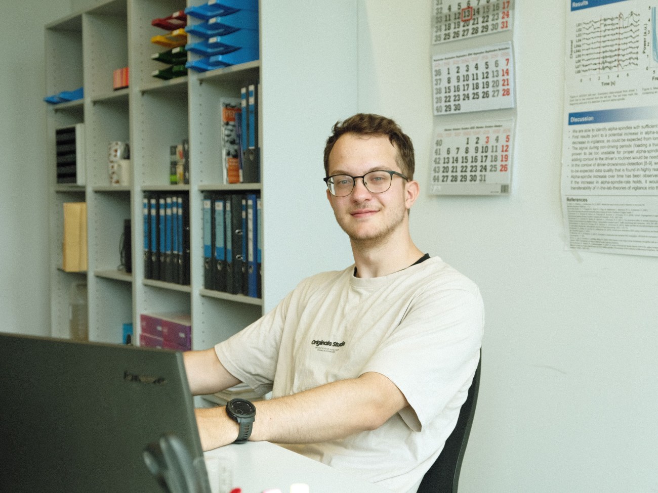 Florian sitzt an einem Schreibtisch in einem Schreibtischstühl.