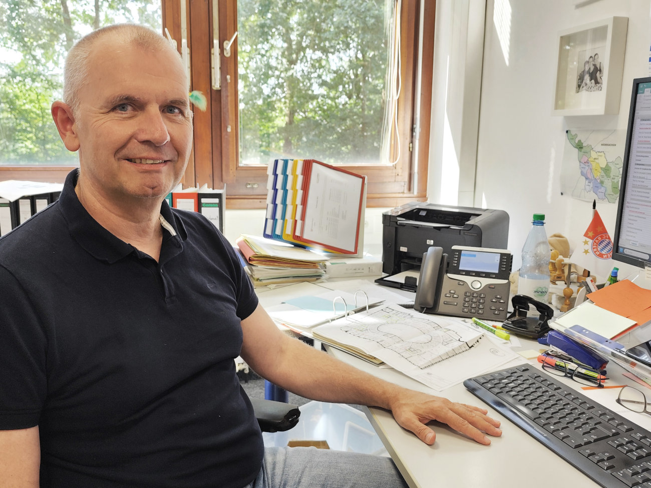 Henri Ohlmann sitzt in einem Büro am Schreibtisch.