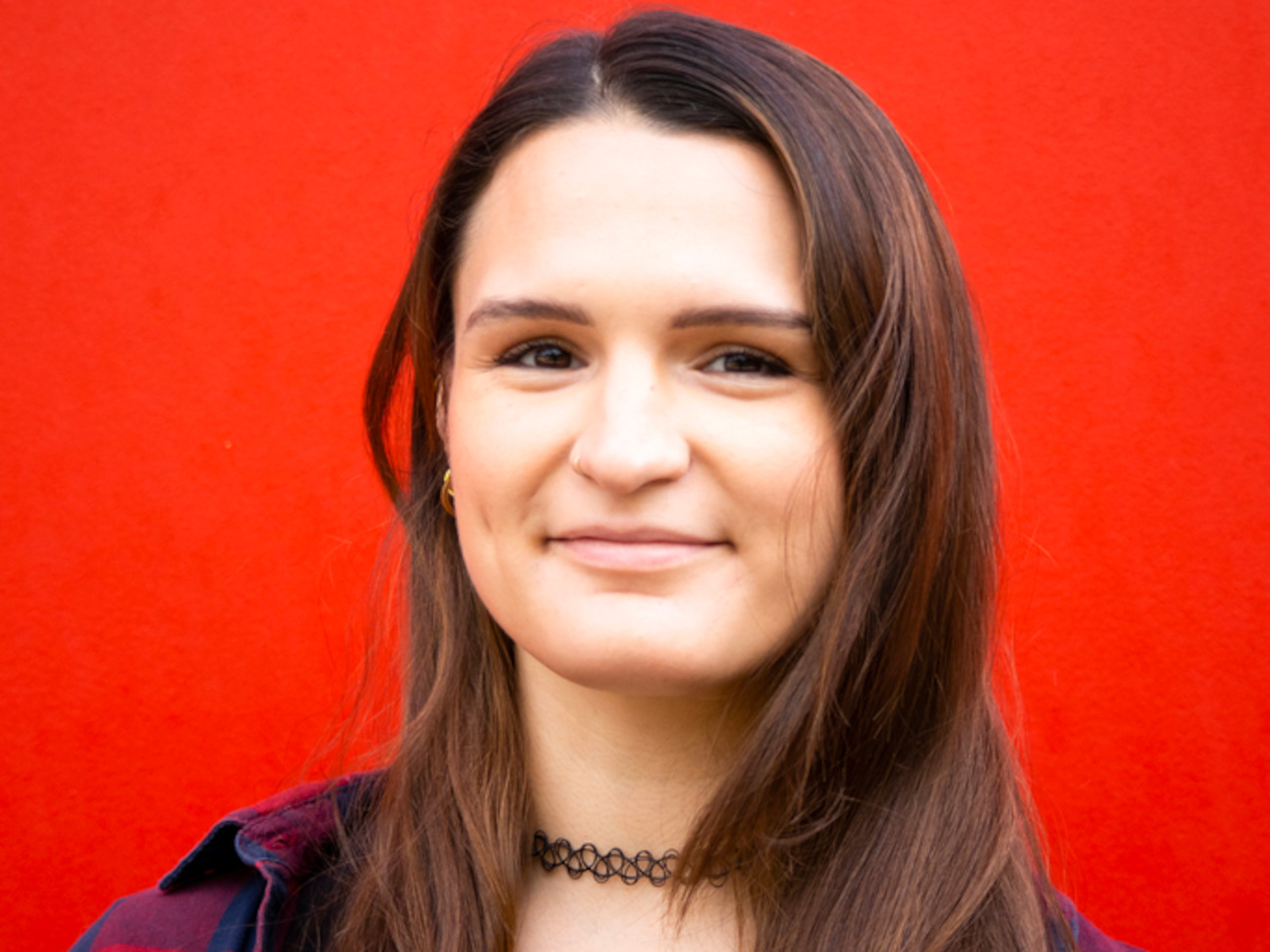 Sarah in front of a red background.