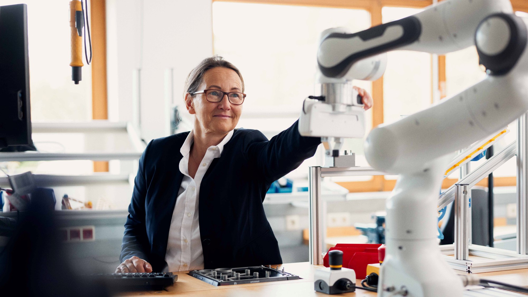 A person operates the computer-controlled arm of a machine.
