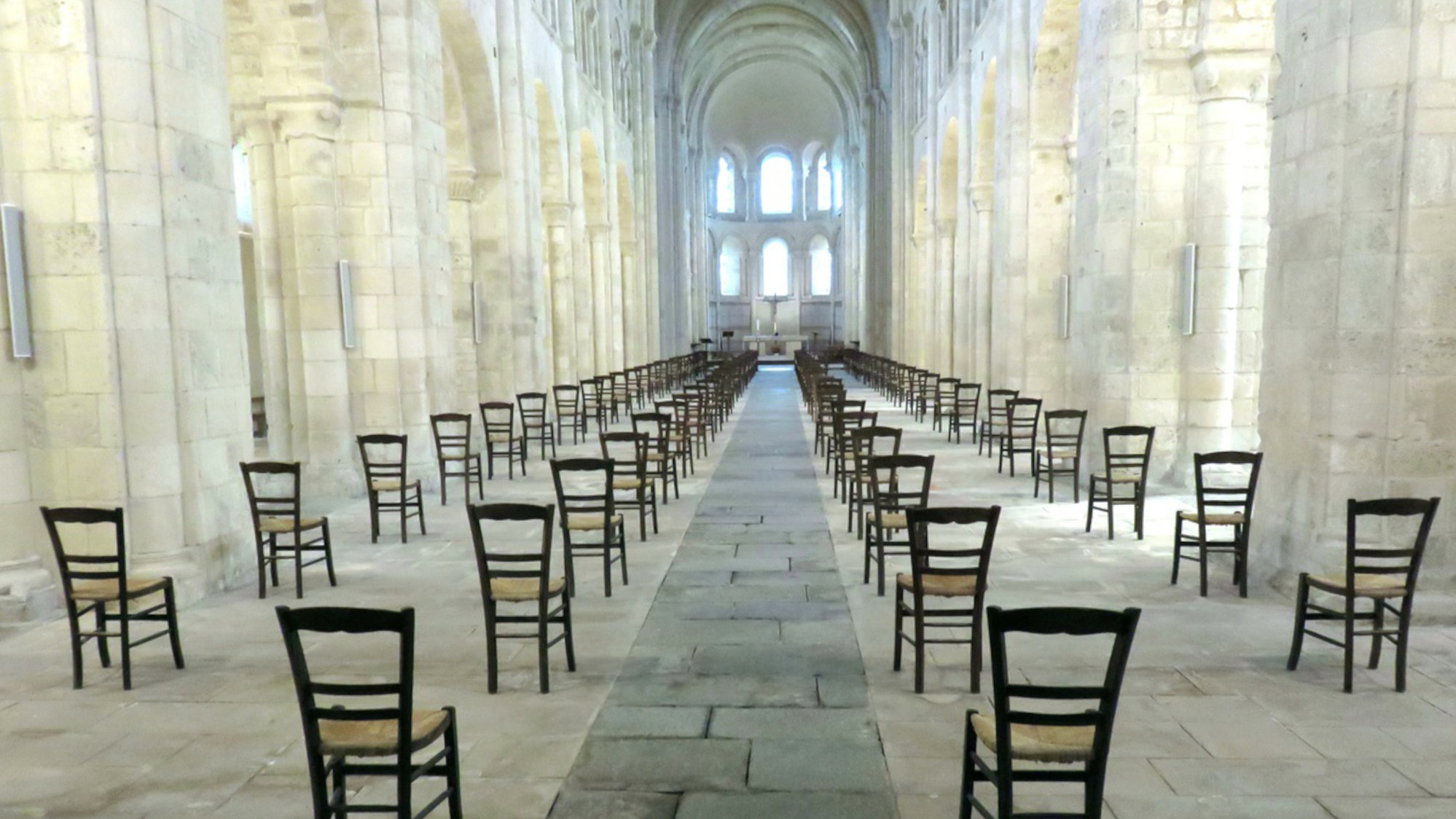 Im Inneren einer Kirche stehen viele Stühle, allerdings ohne Menschen