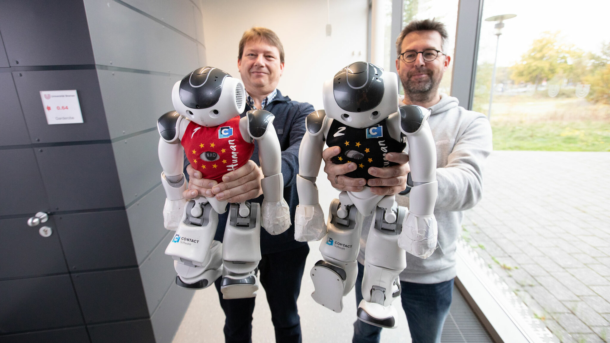 Dr. Thomas Röfer and Dr. Tim Laue hold the robot kickers in their hands