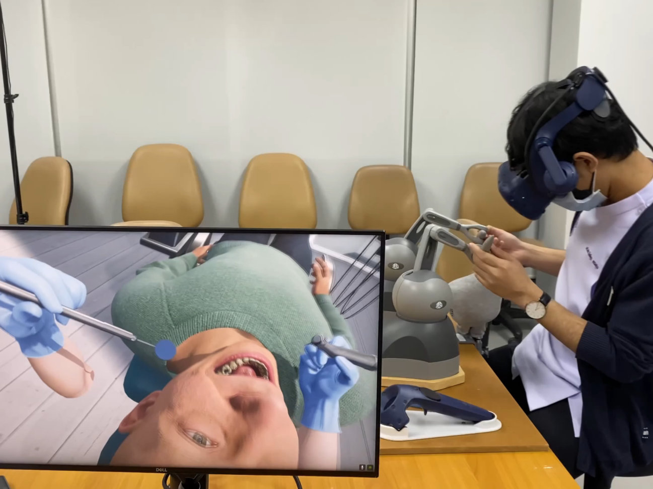 A person performs a dental treatment using a virtual training system.