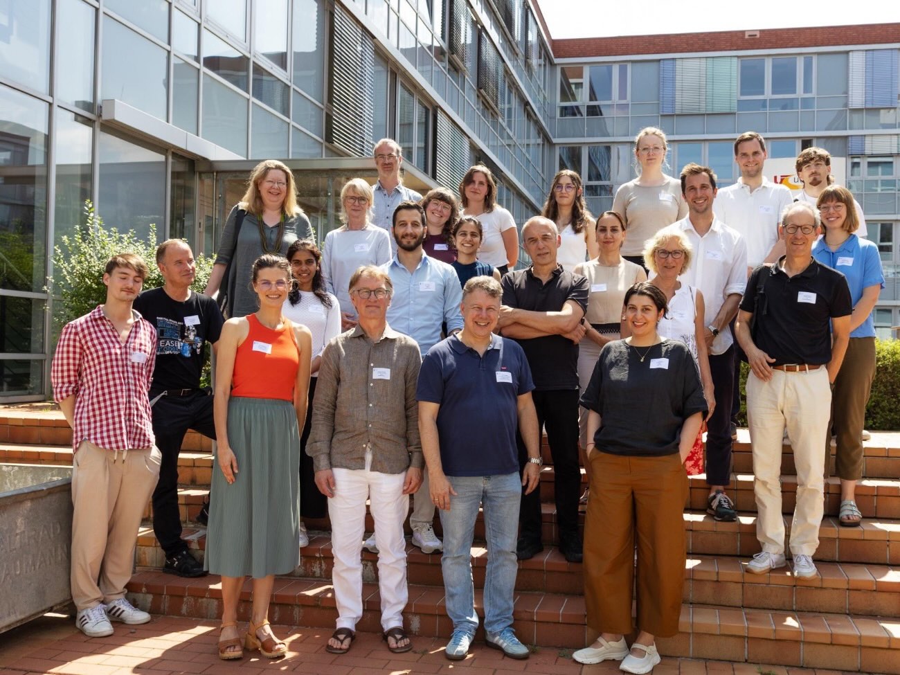 The DataNord team is gathered on the steps in front of a building. 