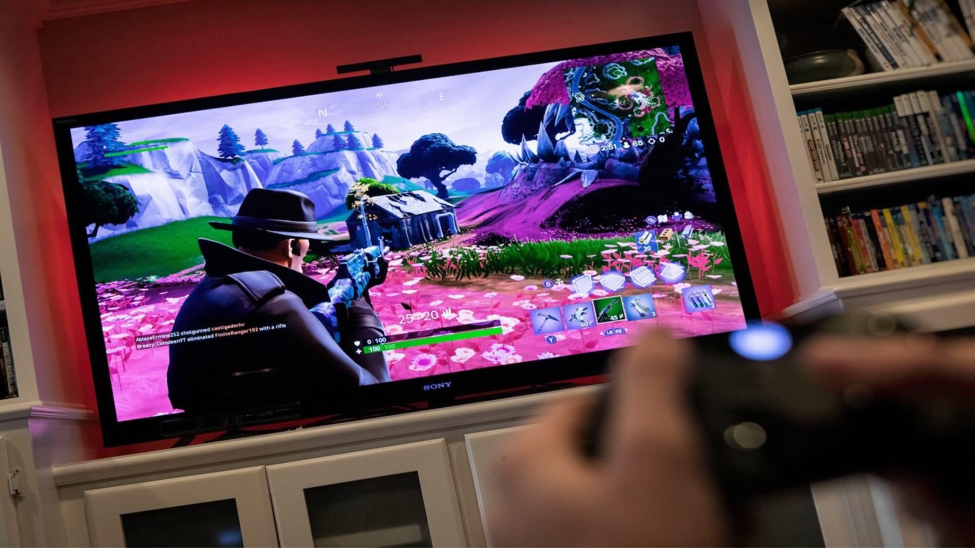 A television screen shows a scene from the game Fortnite.