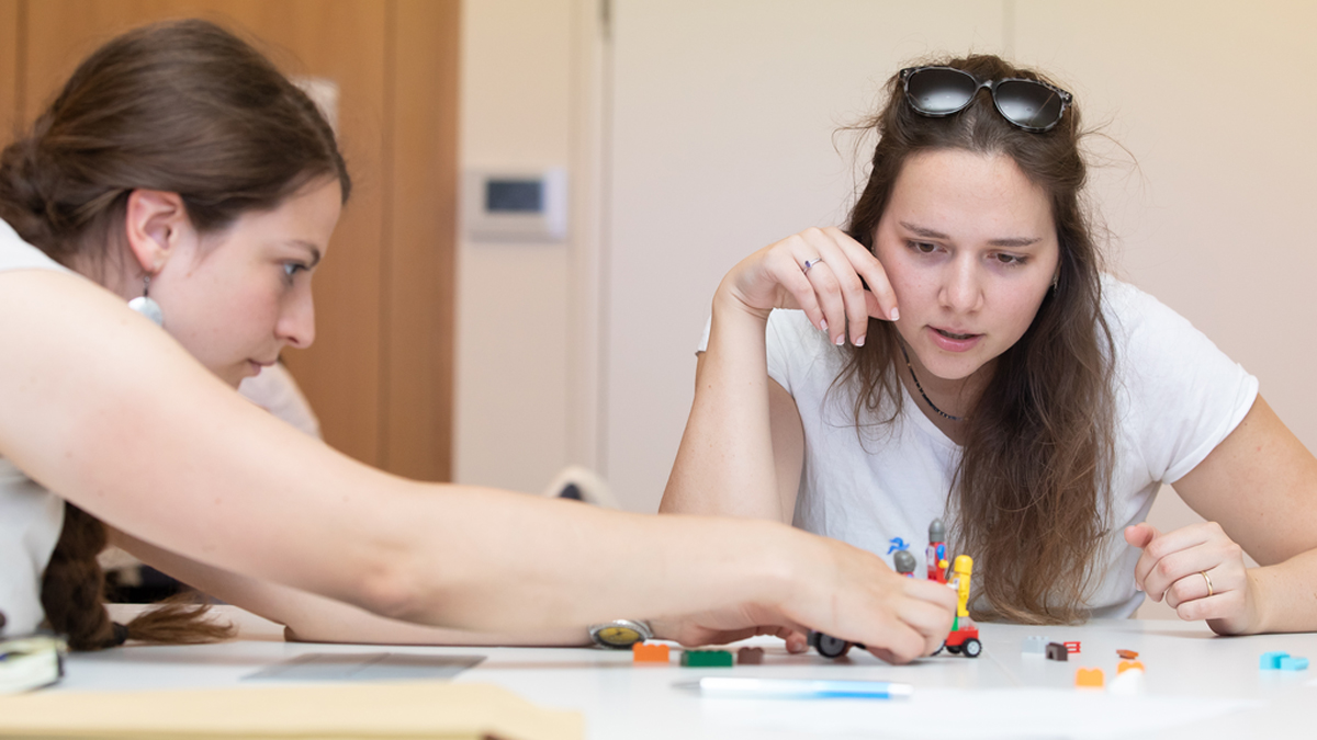 Zwei Frauen bauen mit Legosteinen.