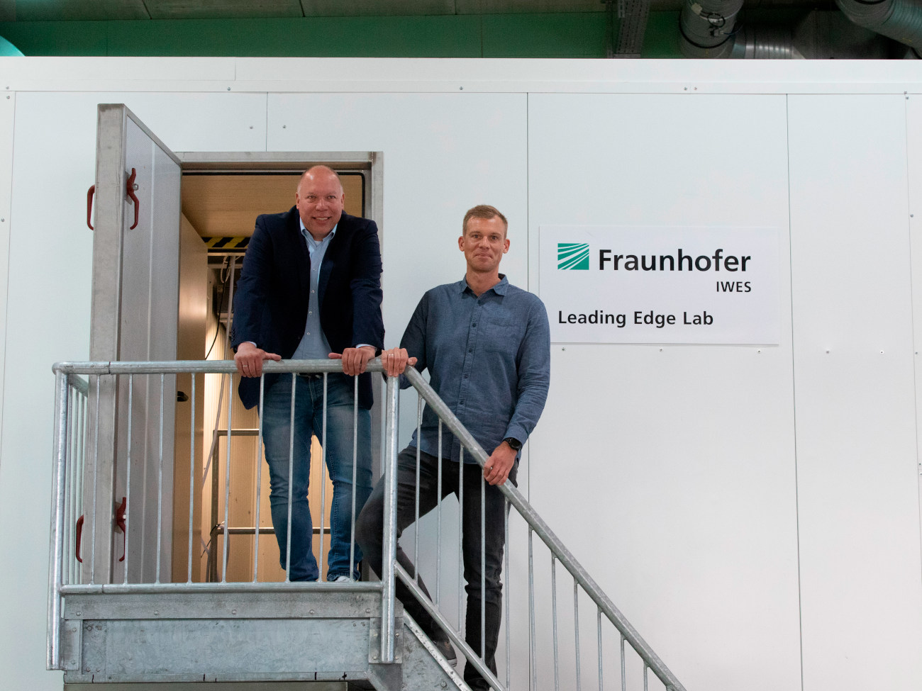 Sascha Buchbach and Stefan Krause stand in front of the entrance of the Leading Edge Lab