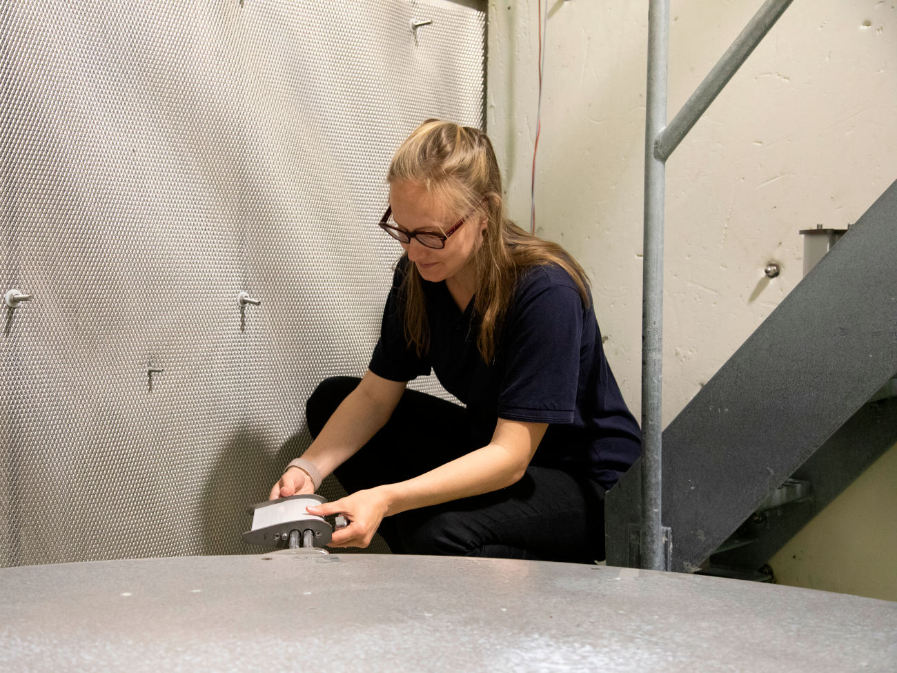 Cate Lester fixes a test object in the rain erosion test bench. 