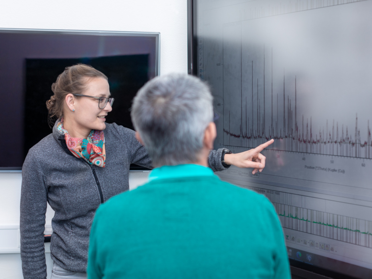 Ella Schmidt zeigt Thorsten Gesing eine Analyse von Beugungsdiagrammen auf einem Bildschirm