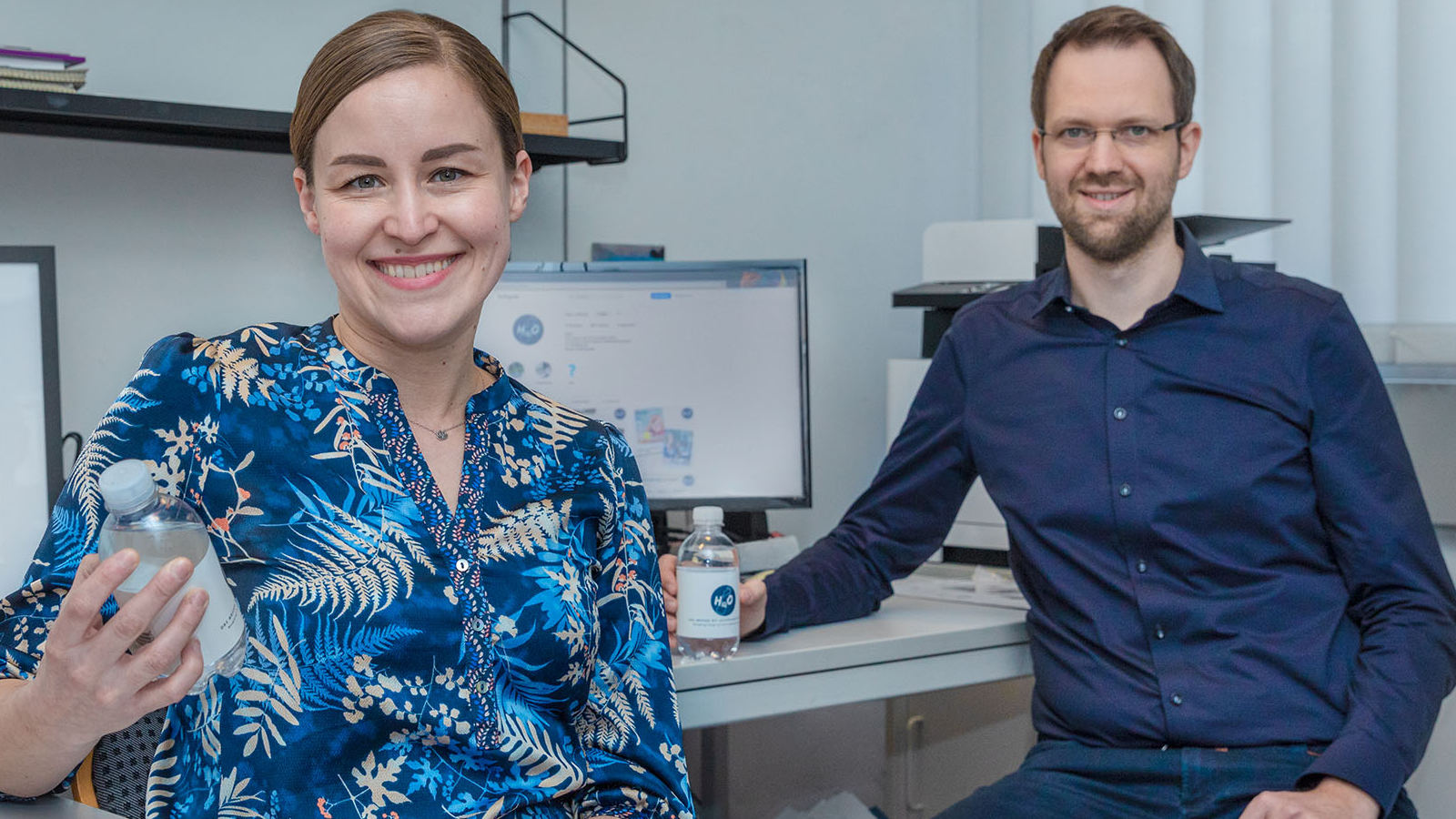 Nadja Belova und Moritz Krause halten Wasserflaschen in den Händen