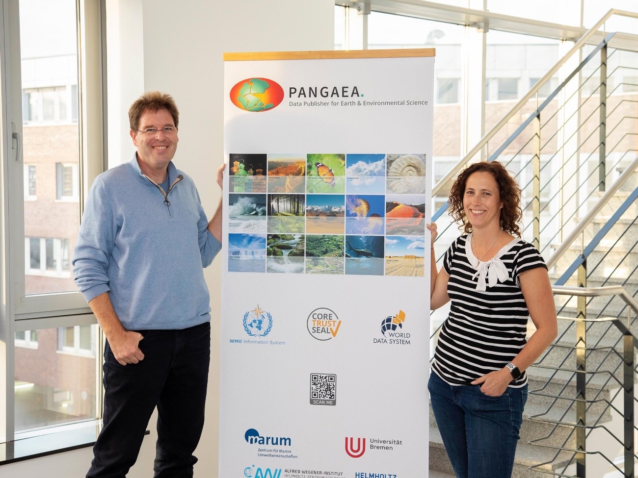 Professor Doktor Frank Oliver Glöckner Glöckner und Doktor Janinen Felden stehen um einen Werbebanner von Pangaea.