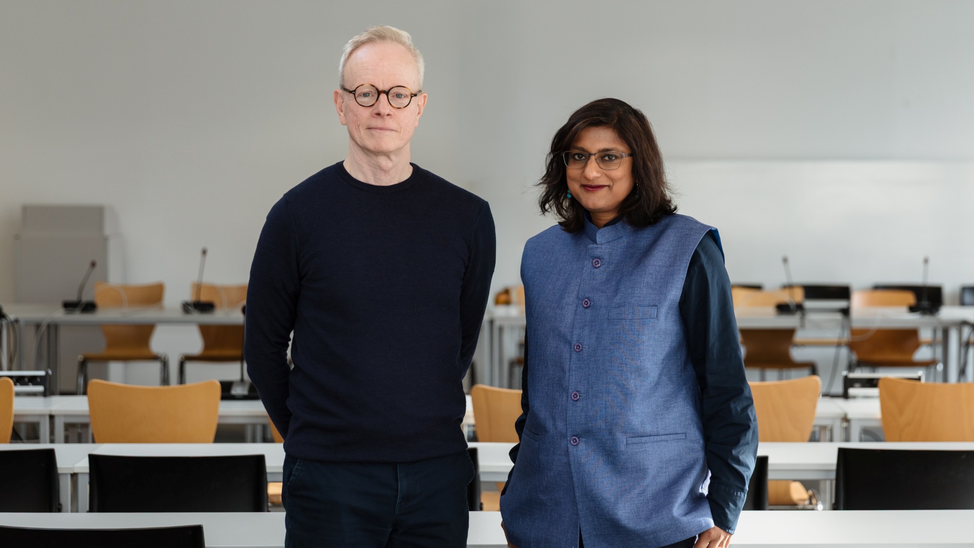 Zwei Personen stehen zusammen in einem Seminarraum