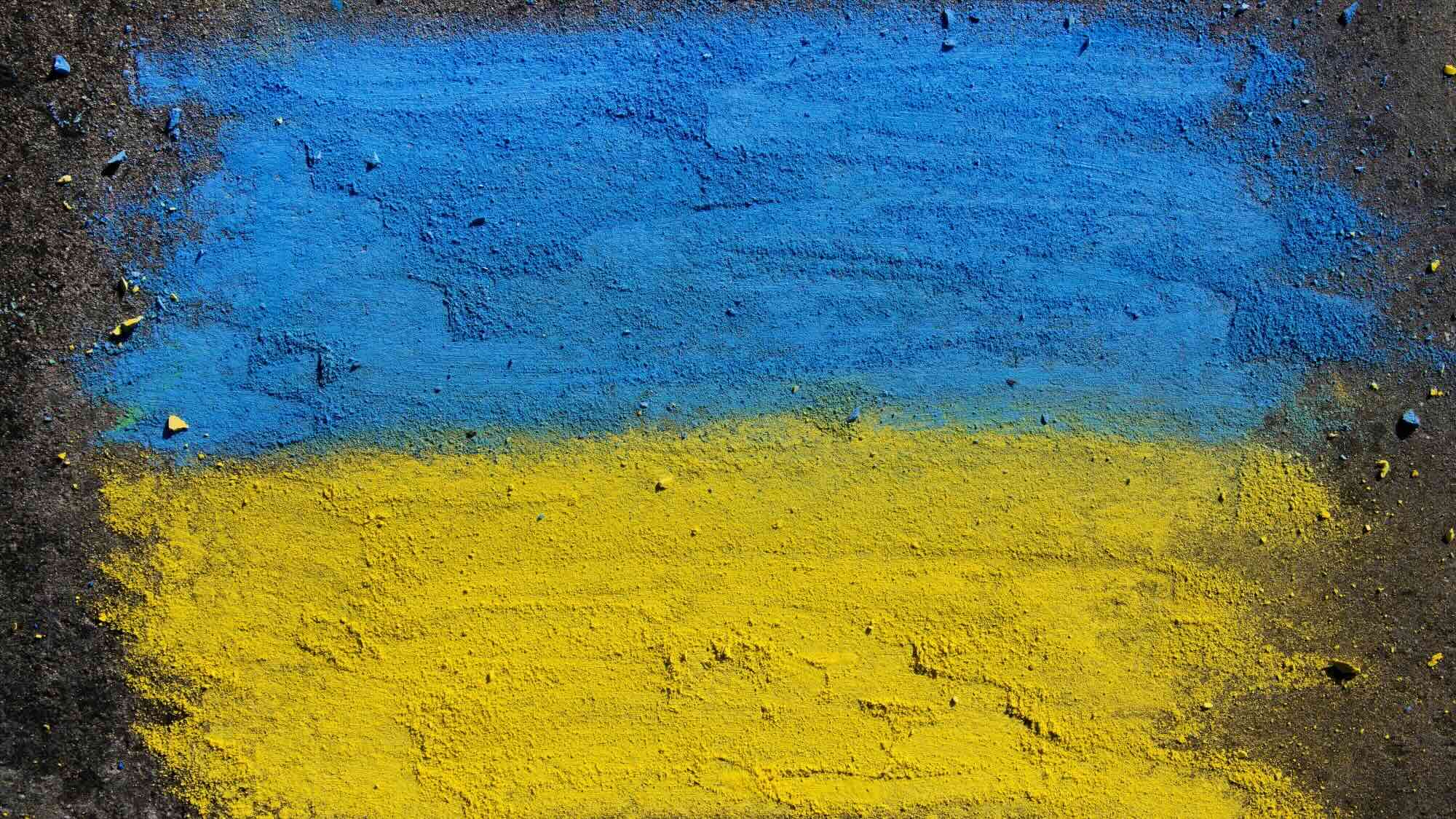 Bild einer Ukraineflagge, die mit Kreide auf dem Boden gemalt worden ist.