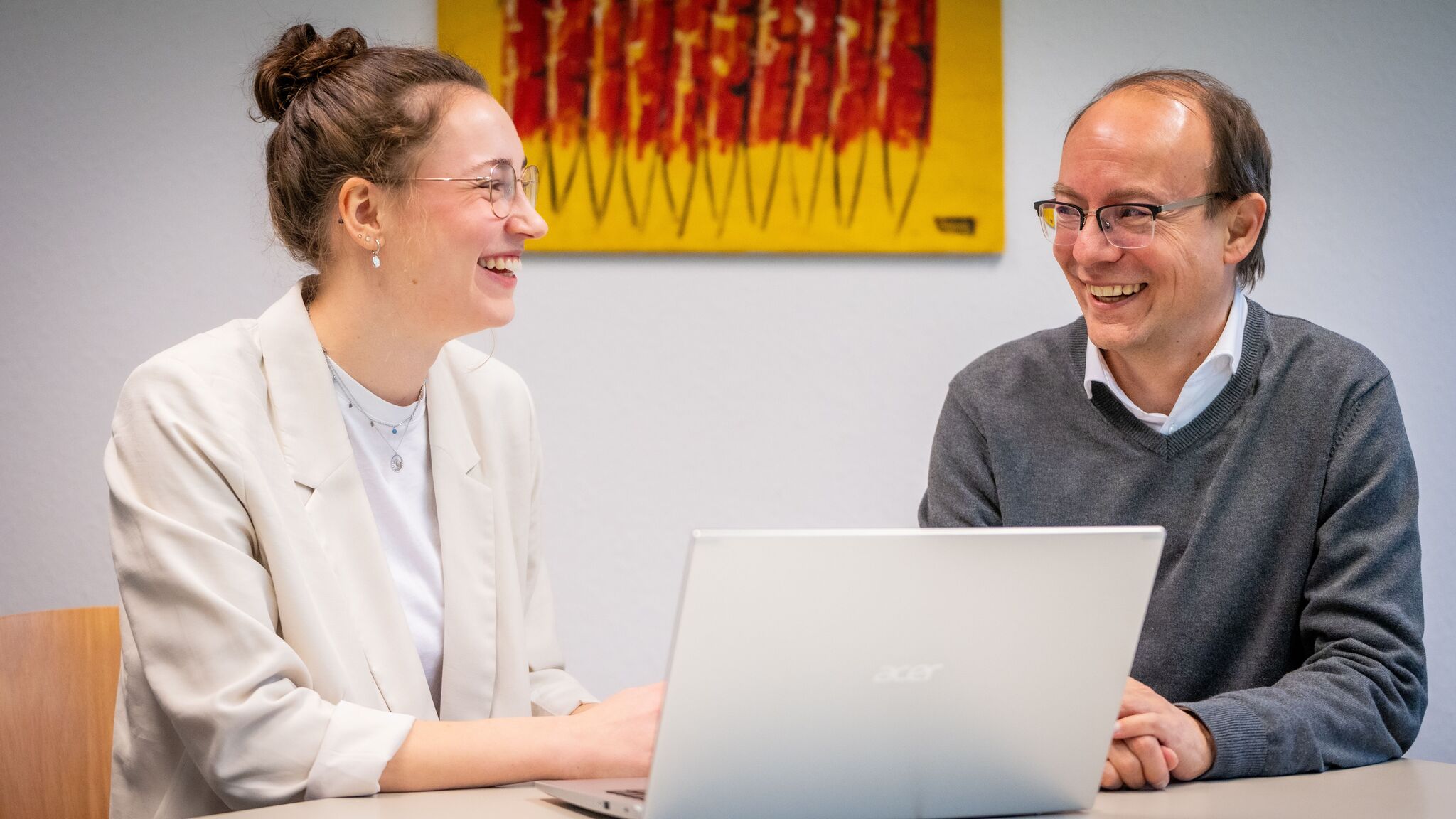 Professor Ansgar Gerhardus und Studentin Sophie Wanger sitzen am Tisch vor einem Laptop.