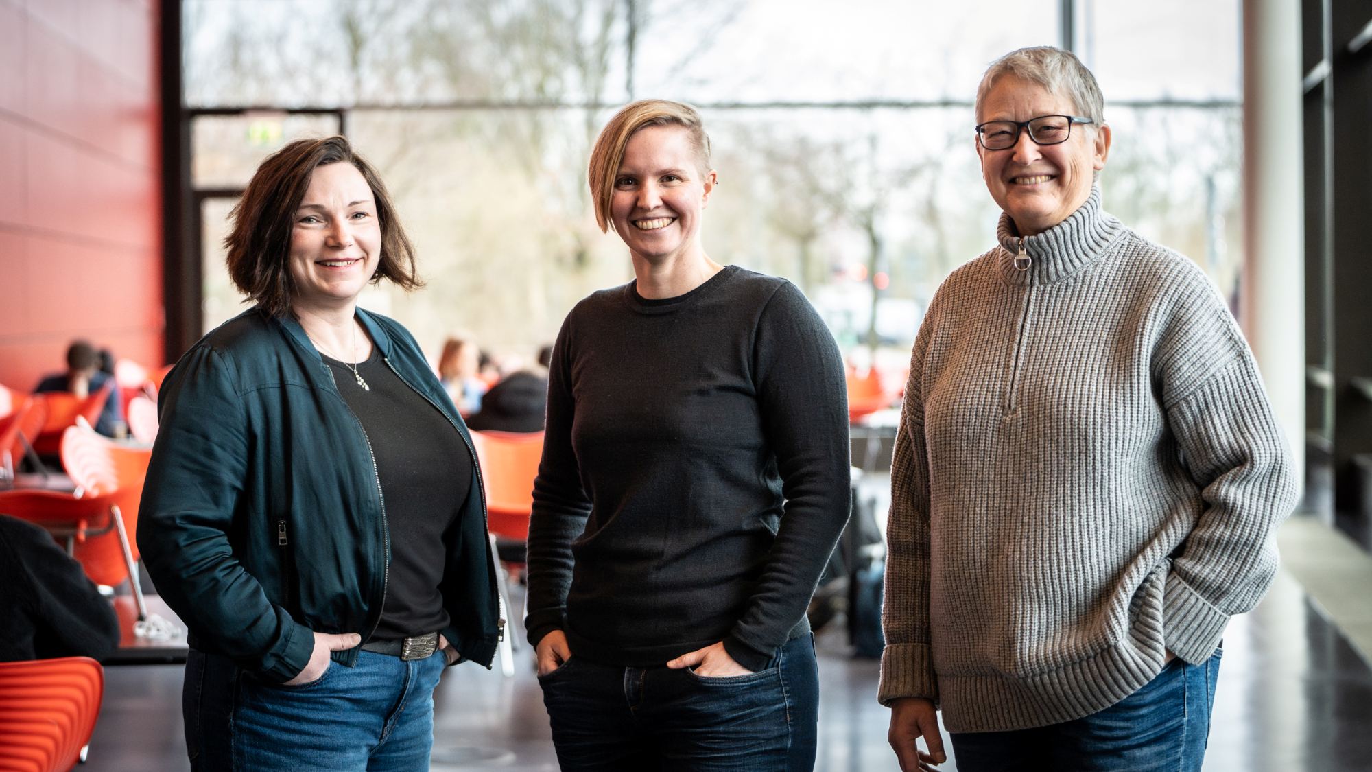 Three women are smiling at the camera.