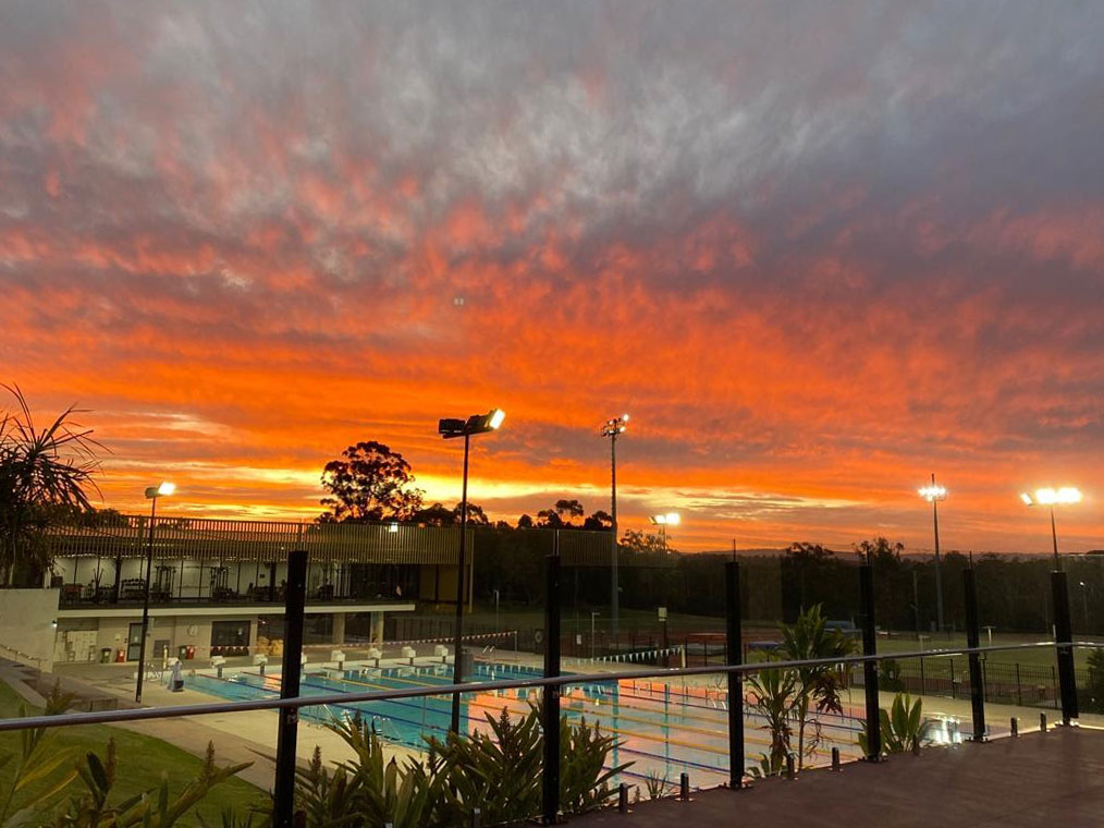 A sunset over an outdoor pool