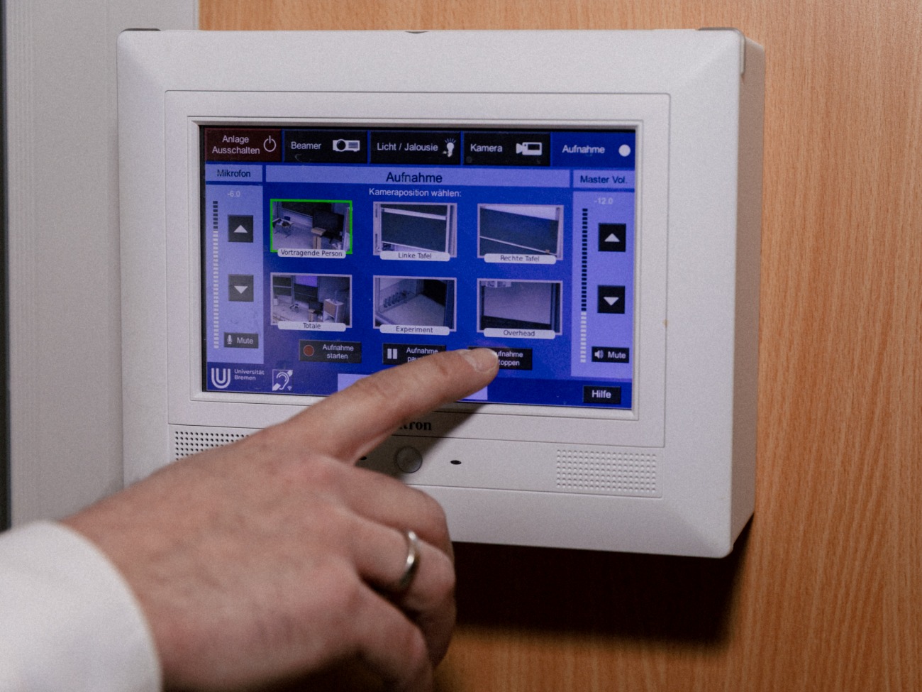 Eine Hand bedient ein Touchpanel.