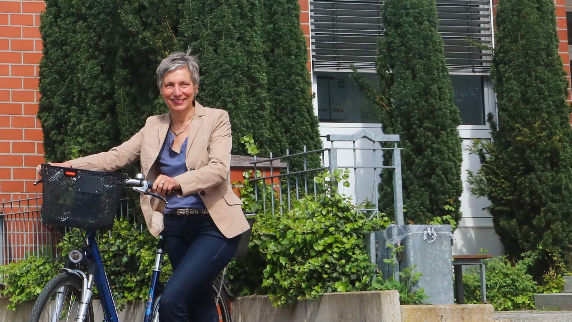 A woman is leaning against a bicycle.