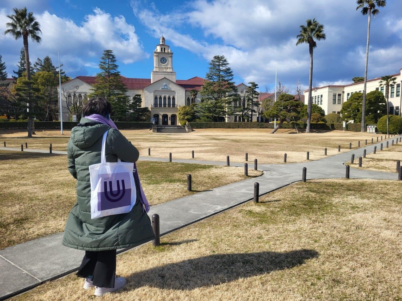 Picture of Jasmin standing in the park in front of the clock tower at the partner university in Japan.