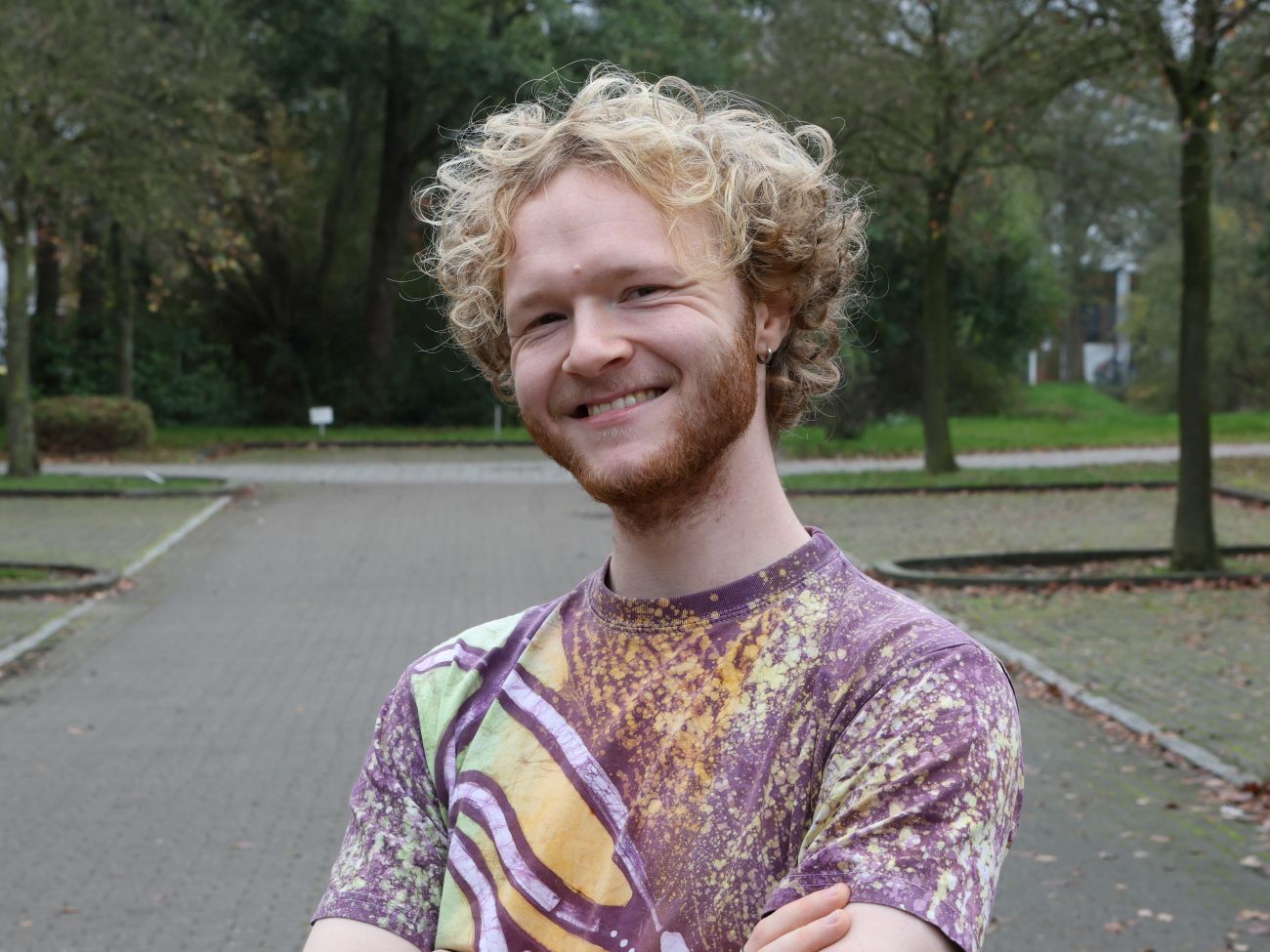 Student standing in a green parking lot.