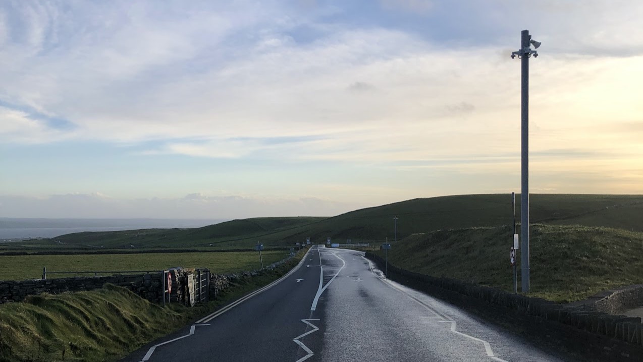 A road at the end of which you can see mountains