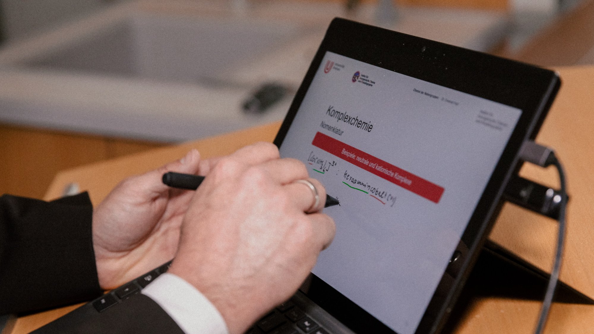 Eine Hand schreibt auf einem Tablet.