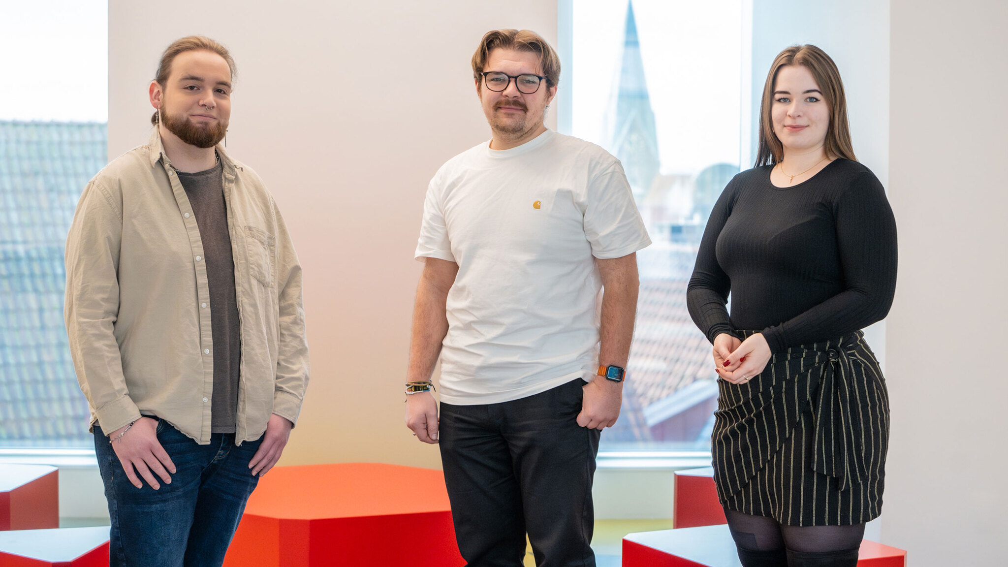 Die Studierenden Nils Kaufholz, Vincent Wagener und Emilia De Rosa posieren in der neuen Mensa am Domshof.