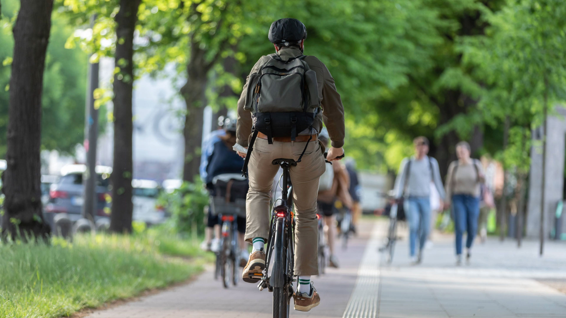 Ein Fahrradfahrer fährt auf einem Fahrradweg hinter anderen Fahrrädern her.