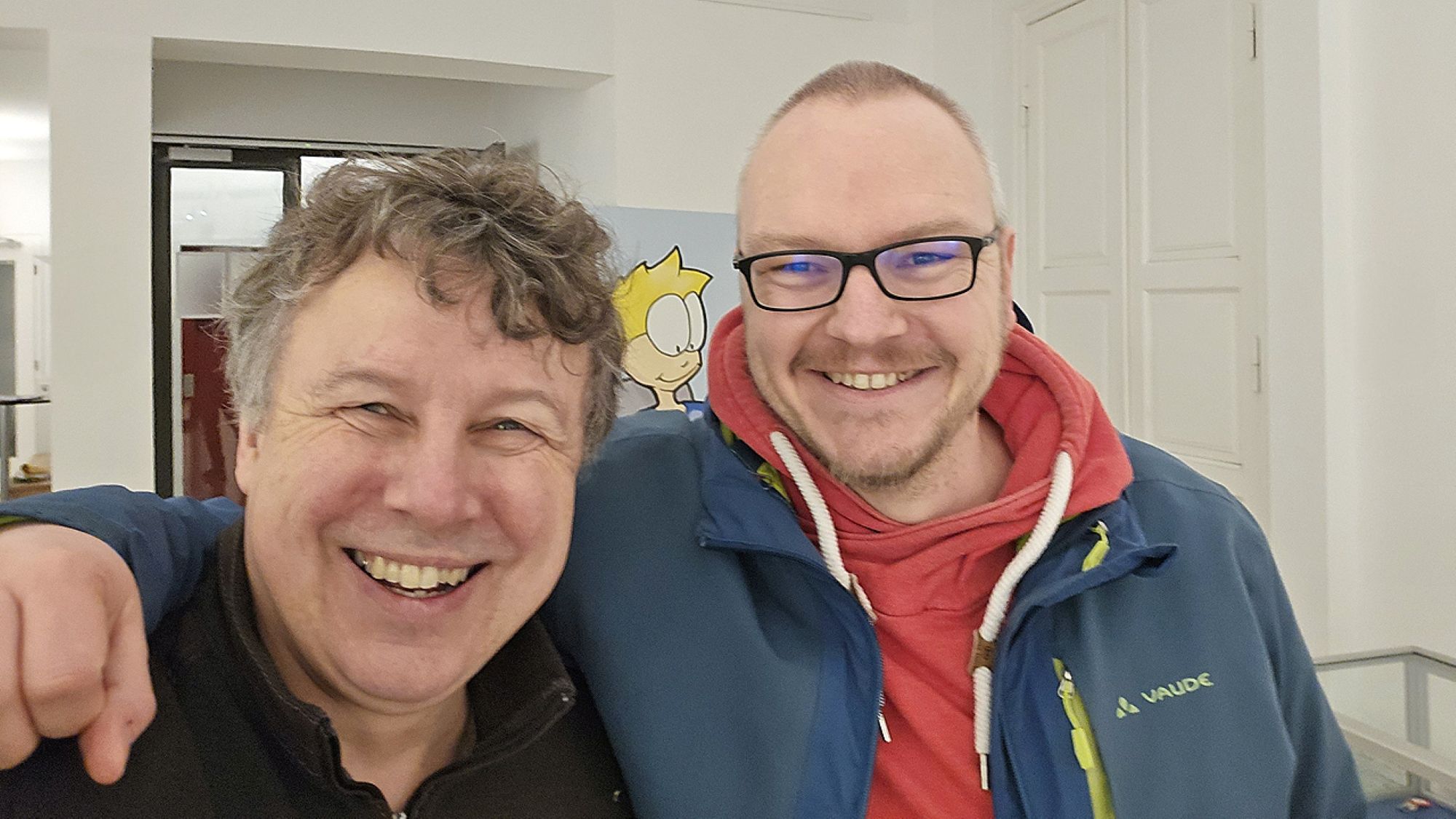 A selfie of two men smiling at the camera.