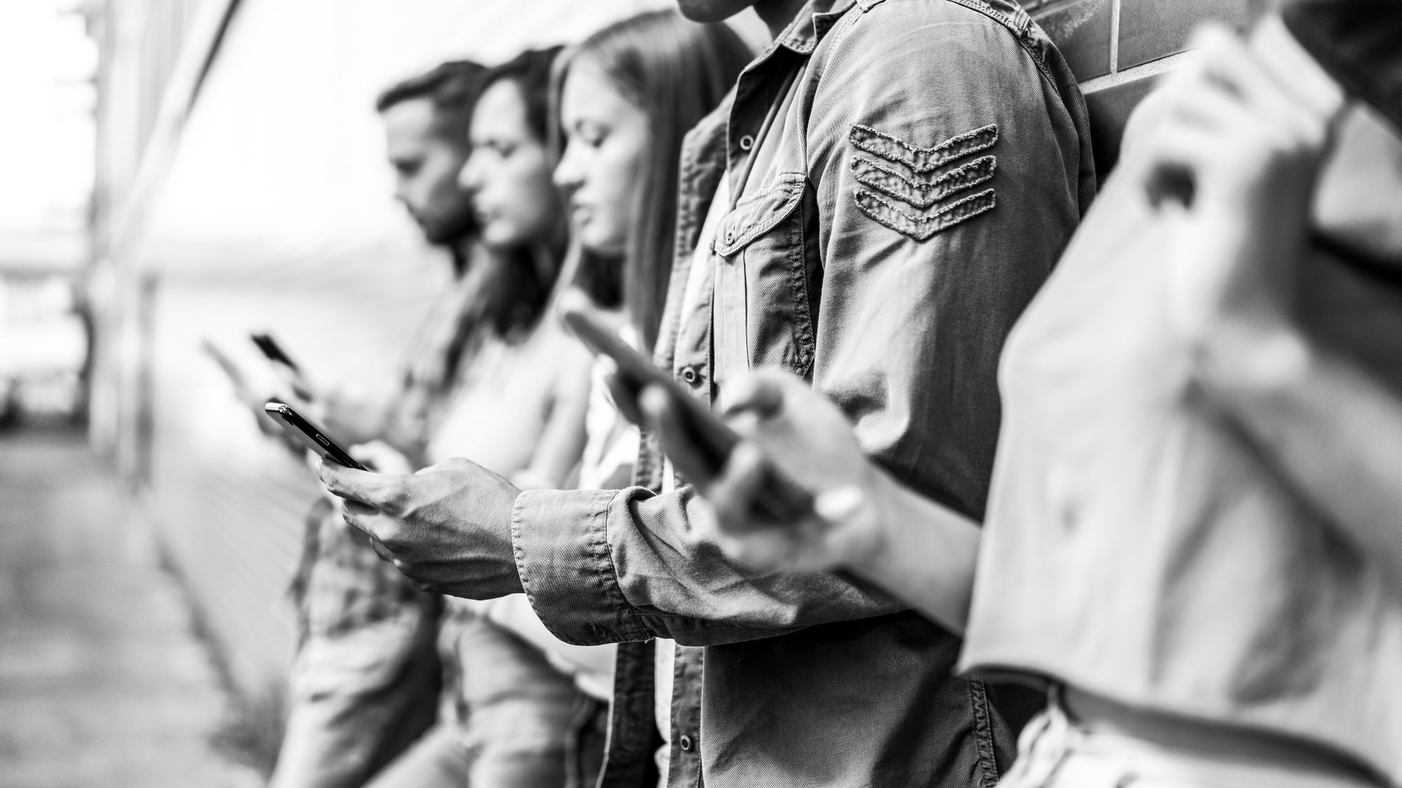 Personen mit Smartphones stehen in einer Reihe.