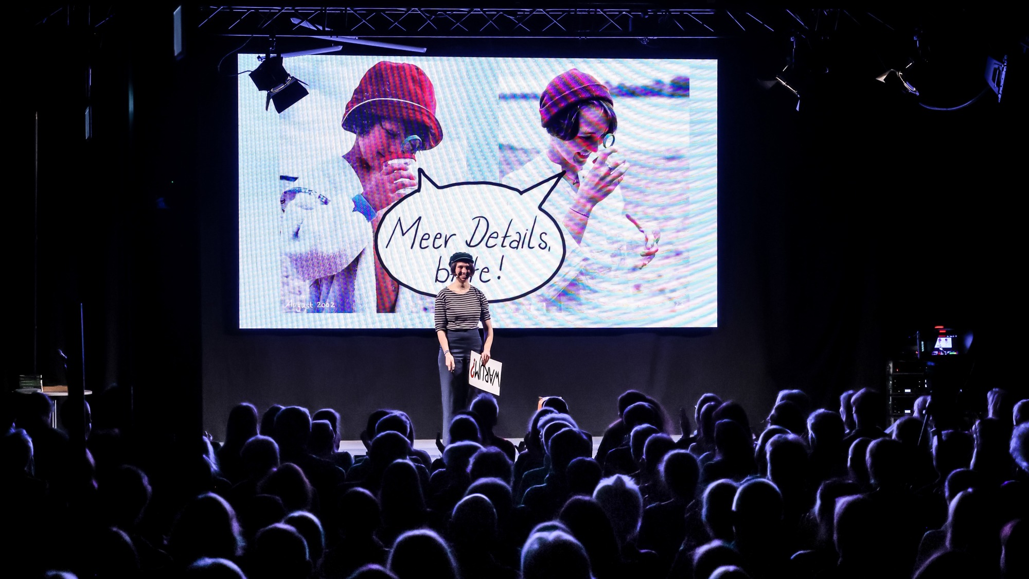 A woman stands on a stage and gives a presentation.