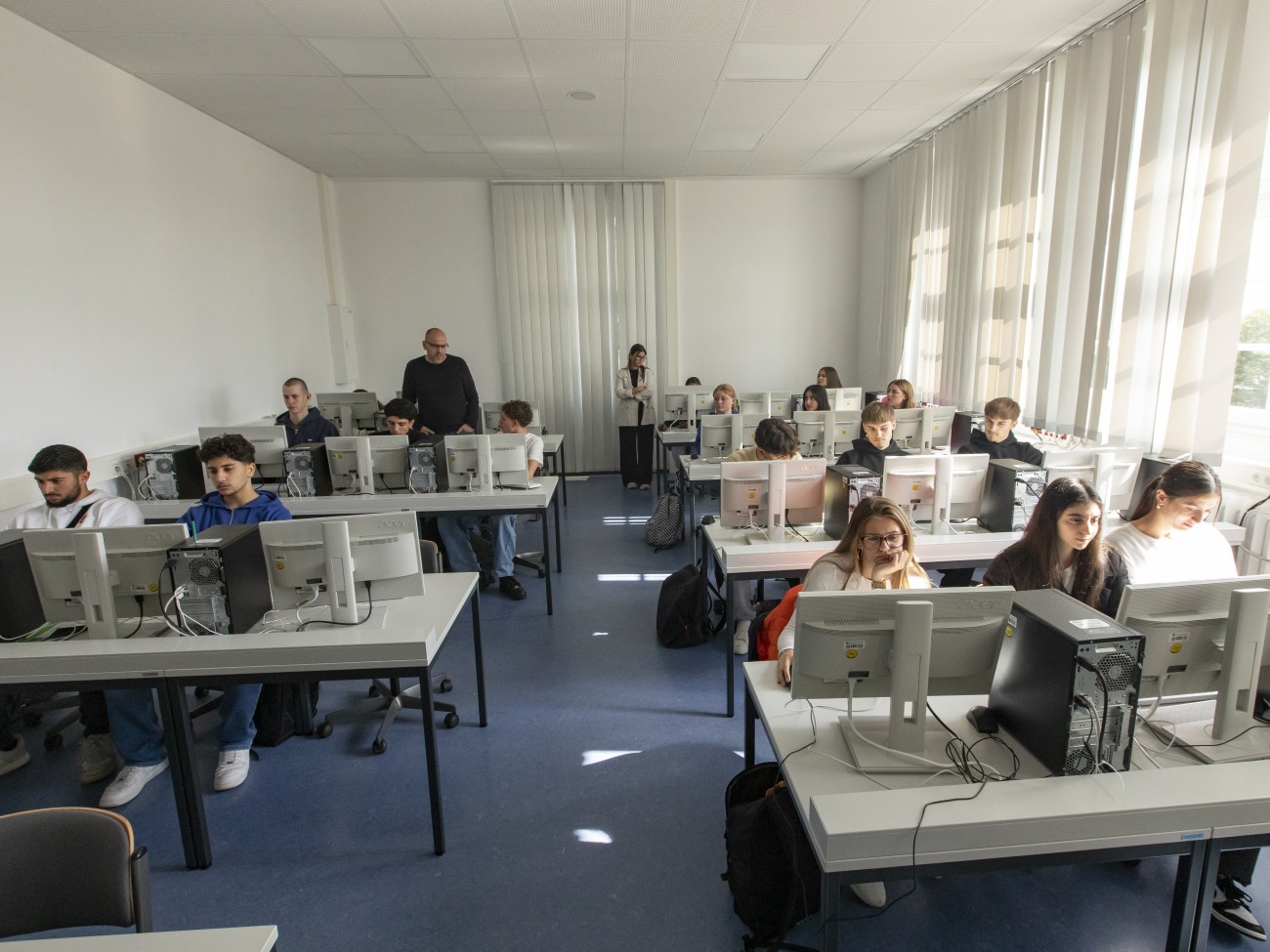 A classroom with students sitting in front of computers.