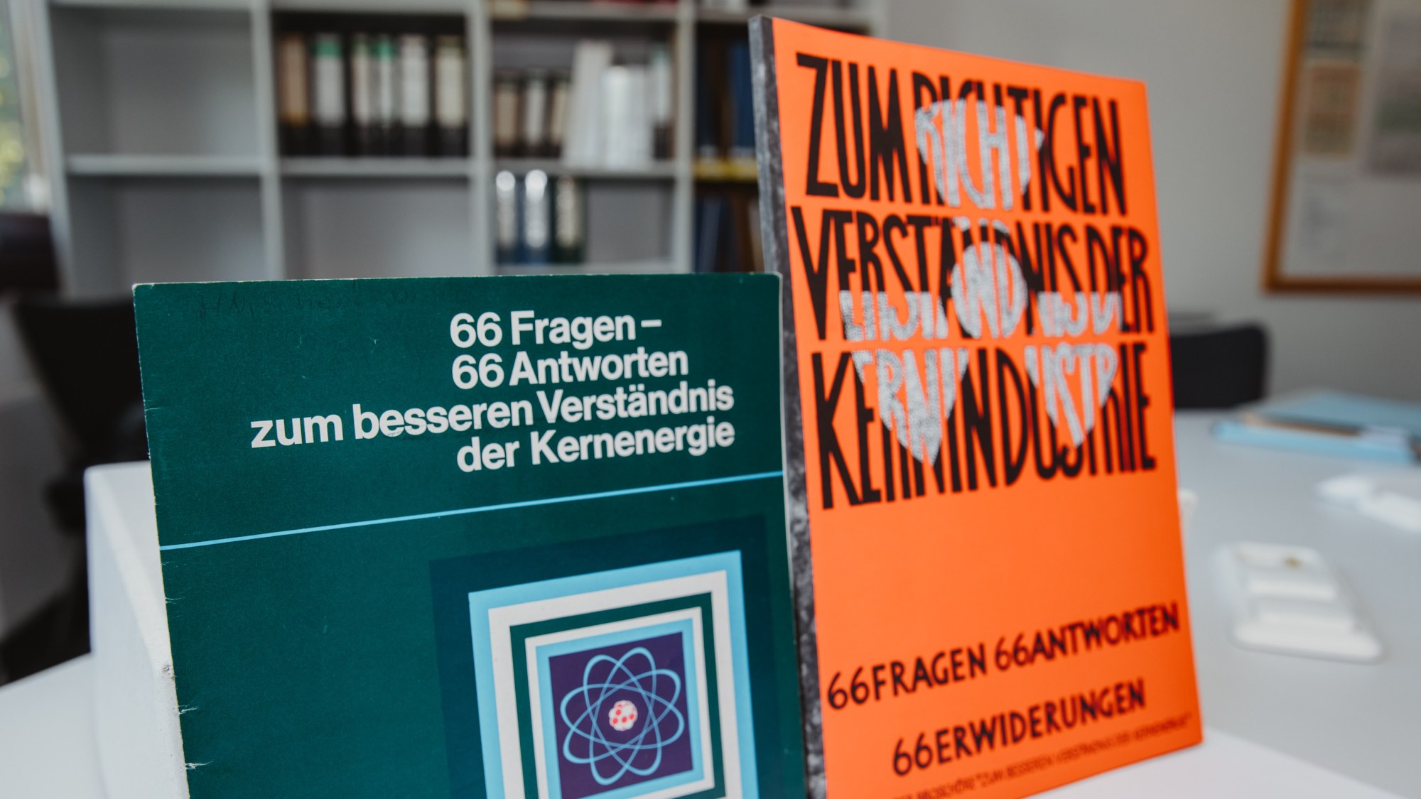 Two books of different sizes are standing next to each other on a table.