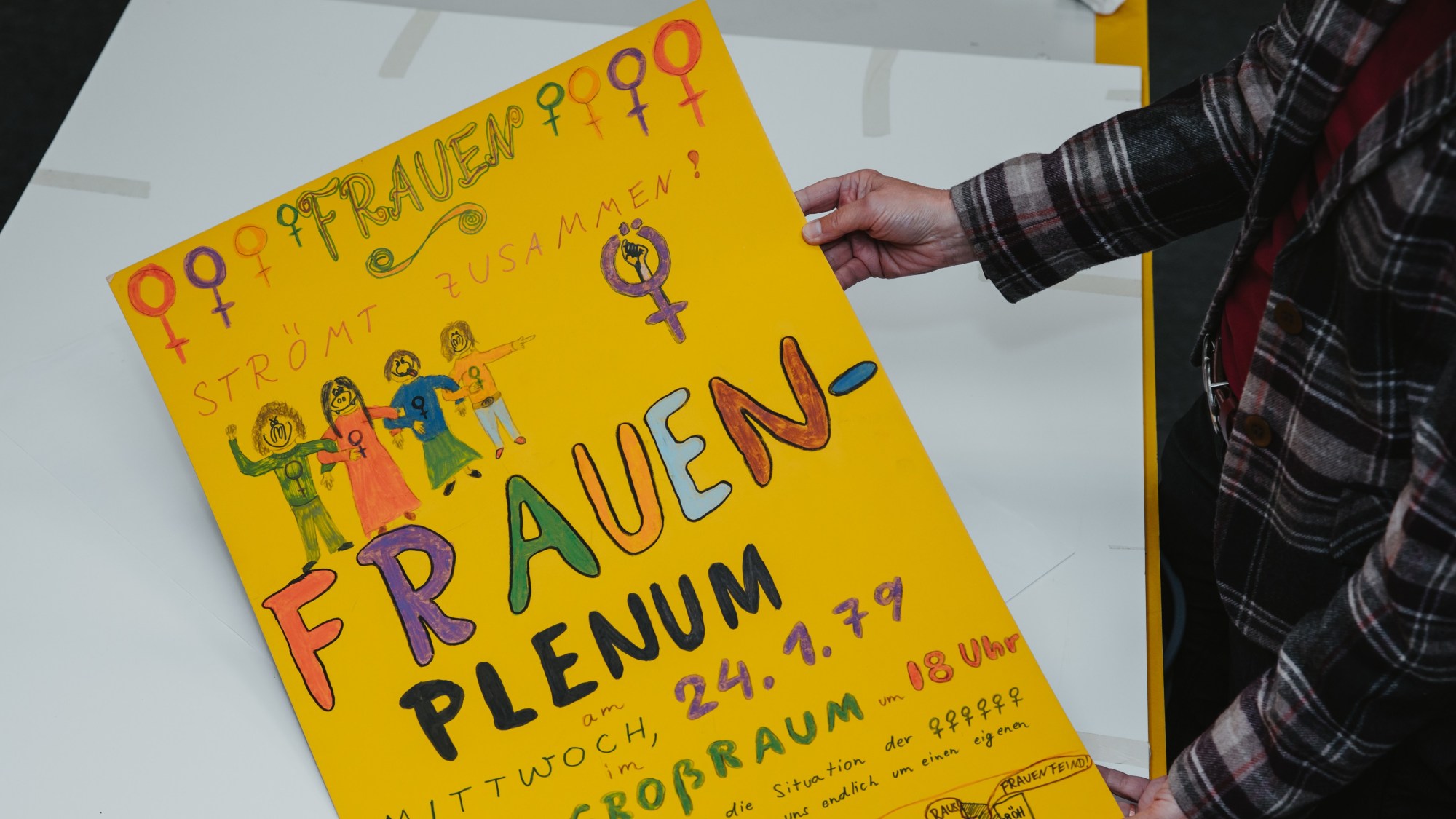 A yellow poster advertising a women's plenary session.